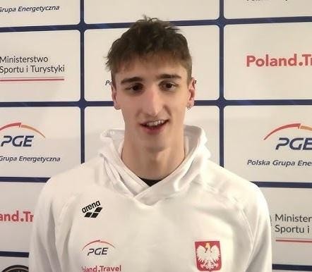 Ksawery Masiuk, zbliżenie na umięśnione plecy pływaka podczas dynamicznego odepchnięcia od ściany w stylu grzbietowym.