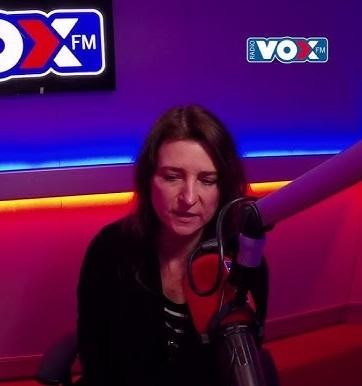 Renata Dąbkowska śpiewająca na scenie podczas występu z zespołem Sixteen, w tle subtelne światła sceniczne.