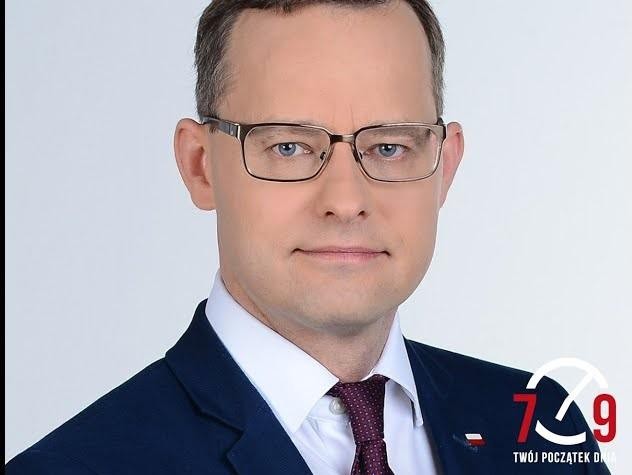Alt: Panorama Biłgoraja, przedstawiająca połączenie zabytkowej architektury z nowoczesnymi elementami urbanistycznymi, symbolizująca miejsce zamieszkania Marcina Romanowskiego.
