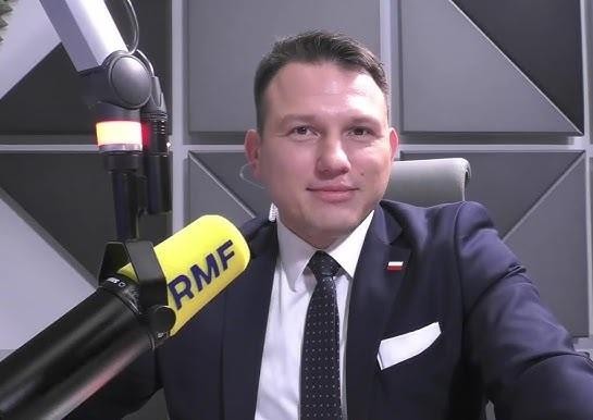 Portret Sławomira Mentzena w garniturze, z dyskretnym tłem sugerującym jego działalność polityczną lub zawodową.