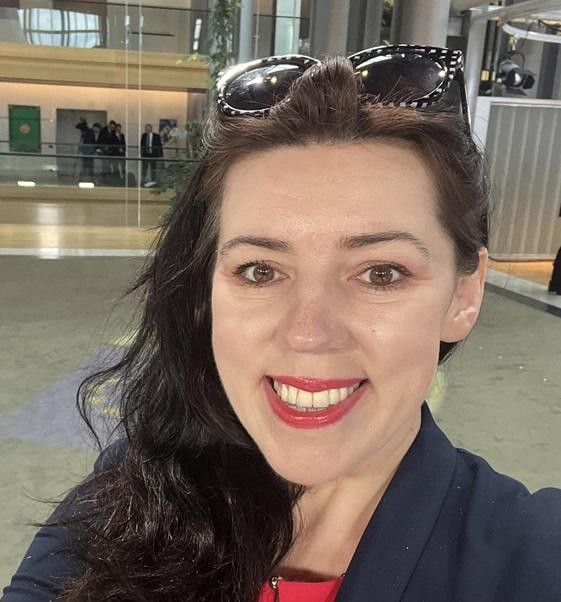 Dominika Ćosić podczas wystąpienia lub interakcji na konferencji, symbolizująca jej aktywną rolę w dziennikarstwie i publicystyce.