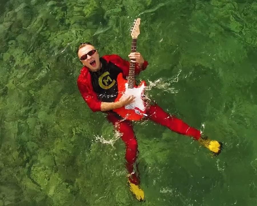Alt: Czadoman (Paweł Dudek) podczas energicznego występu na scenie, w otoczeniu dynamicznych świateł, oddający się muzyce.